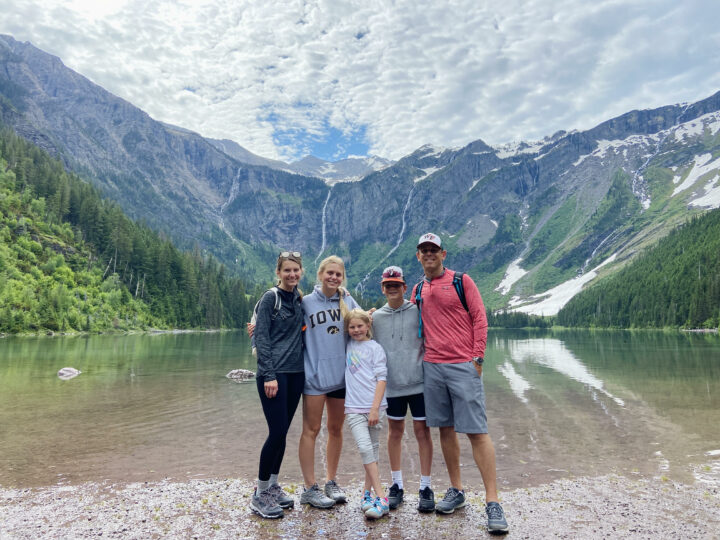 Zenker family of 5 standing in front of a body of water and mountains